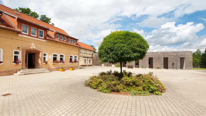 Blick in den Innenhof. Auf der linken Seite befindet sich das Verwaltungsgebäude und im Hintergrund die Holzwerkstatt.